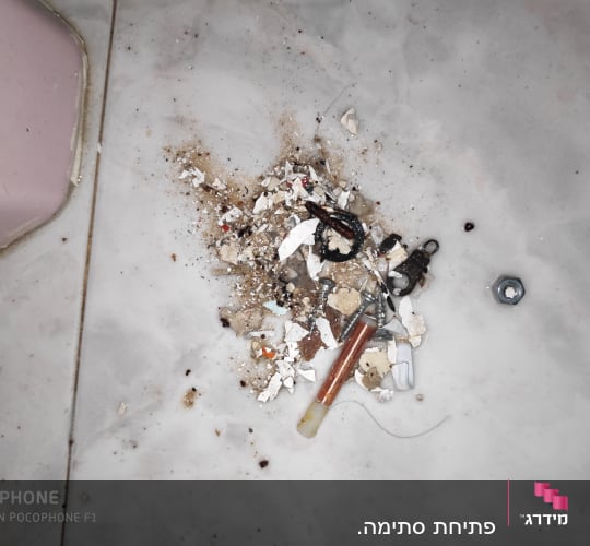 ברגים, אומים וחלקי צנרת על רצפה מלוכלכת